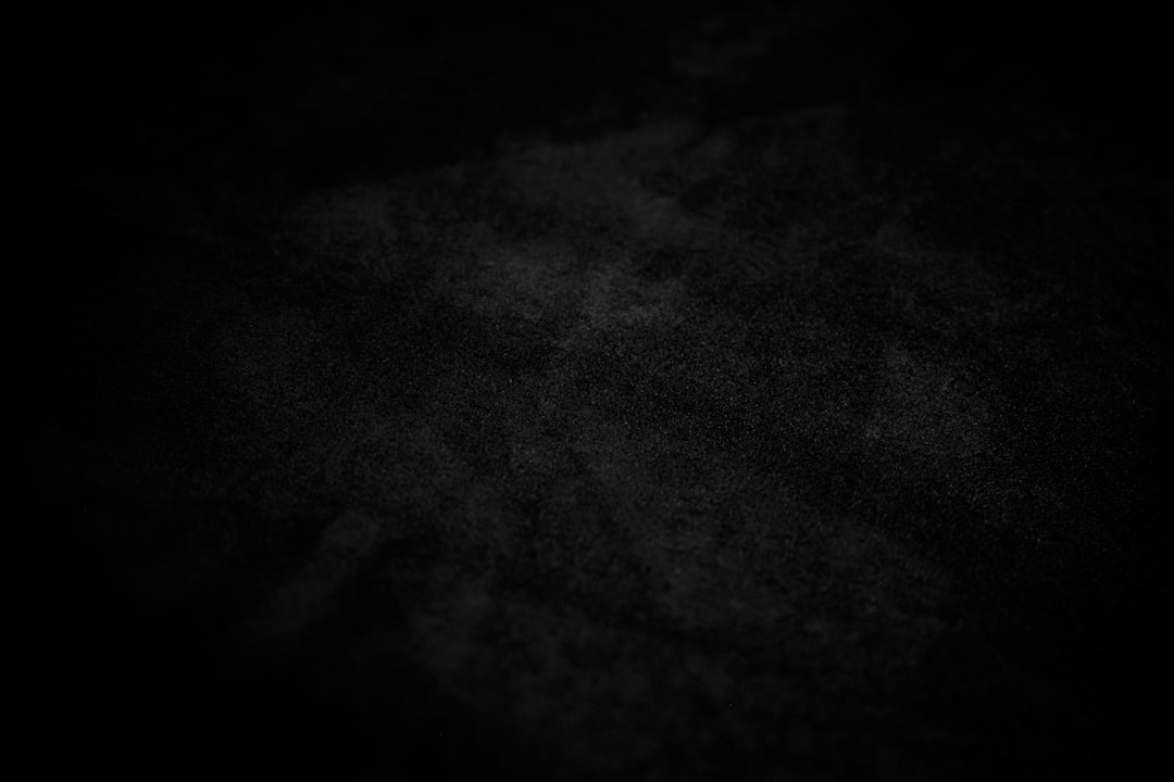 A dark, textured background with subtle light effects.