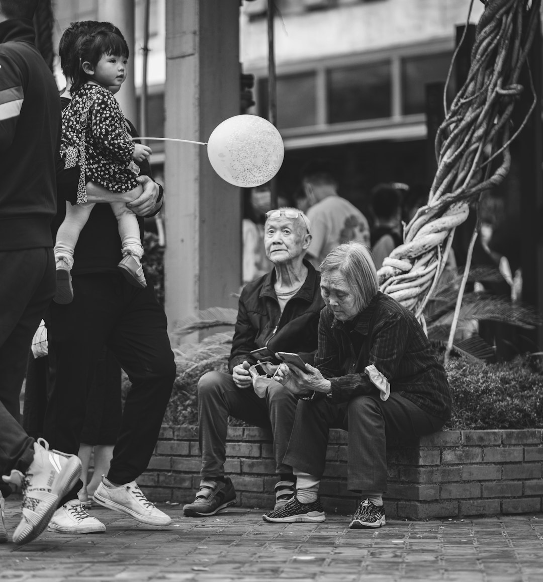 grayscale photo of 2 women sitting on bench
